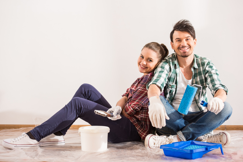 tired-young-couple-are-sitting-floor-with-paint-brush.jpg