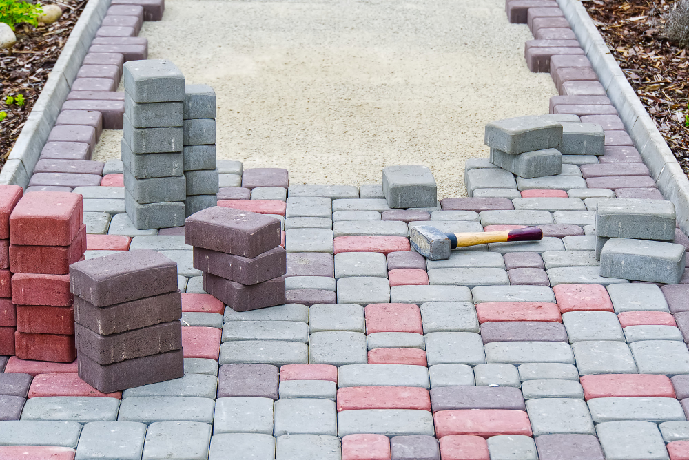worker-laying-paving-stones-stone-pavement-construction-worker-laying-cobblestone-rocks-sand